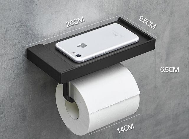 black toilet paper holder with storage shelf and bathroom accessories